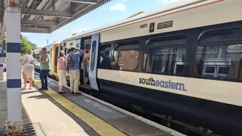 Getty Images Passengers and commuters boarding a Southeastern train at Margate station on a bright and sunny summer day