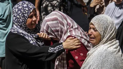 EPA Women mourn those killed in the strike on a school sheltering displaced people