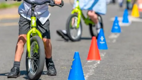 Leicester City Council Children cycle around a cone on the street