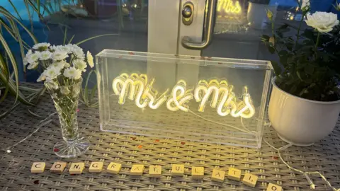 LOROS A Mr and Mrs Lamp and flowers on a table