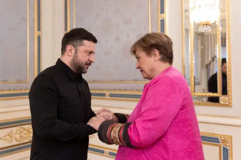 Reuters  Volodymyr Zelensky, dressed in a black shirt, welcomes Kristalina Georgieva in Kyiv has the two talk over their clasped hands