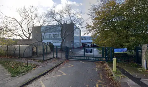 Google Google Street view of a three-storey 1960s school building behind closed metal gates
