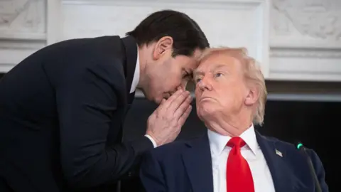 Marco Rubio whispers into Donald Trump's ear.