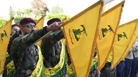 EPA File photo showing Hezbollah members holding up the group's flags at a ceremony in Beirut, Lebanon (7 September 2024)