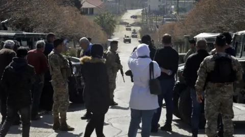 EPA Villagers wait at a roadblock outside Kfarkela (18/02/25)