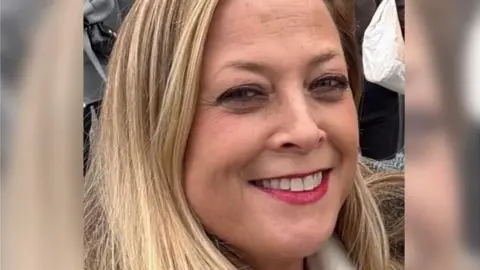 Close-up of Annabel Rook smiling at the camera. She had blonde hair and red lipstick.