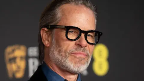 Getty Images Guy Pearce wearing black round glasses