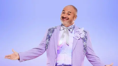 PA Media A man dressed in a light purple, glitzy ballroom suit