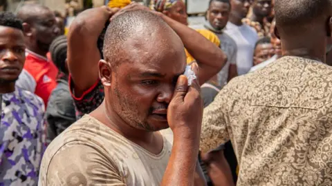 Getty Images Tim penyelamat mencari korban selamat di reruntuhan gedung 21 lantai yang runtuh saat sedang dibangun di kota terbesar di Nigeria, Lagos pada 2 November 2021.