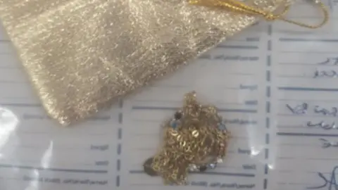 Gloucestershire Constabulary A gold chain and small gold pouch bag are seen in a police evidence bag.