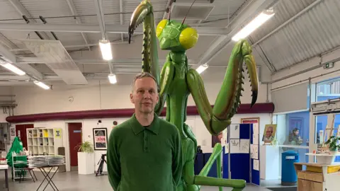 BBC David Shrigley with his Mantis sculpture at Beauchamp College, Oadby, Leicestershire