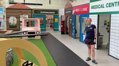 Rachael Parker stood inside the empty play area, which is modelled after a high street, complete with the supermarket, vet's clinic, medical centre, and café.