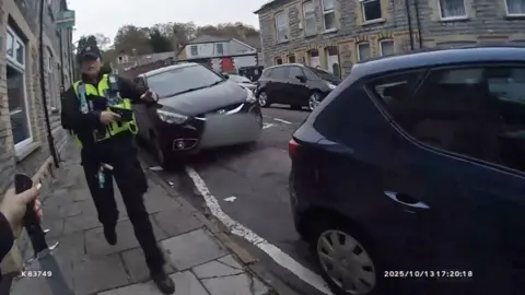 Police officer passes knife over to a colleague 