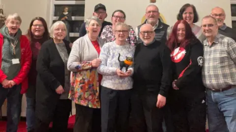 Lost Chord UK An image of 13 men and women smiling