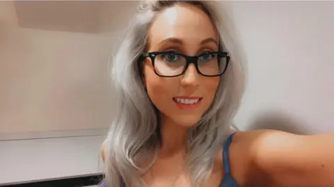 suppied A young woman with light blonde hair taking a selfie