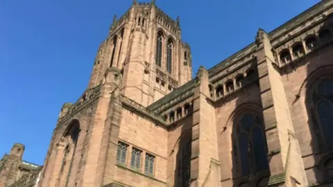 An outside view of Liverpool Cathedral with clear blue skies above it