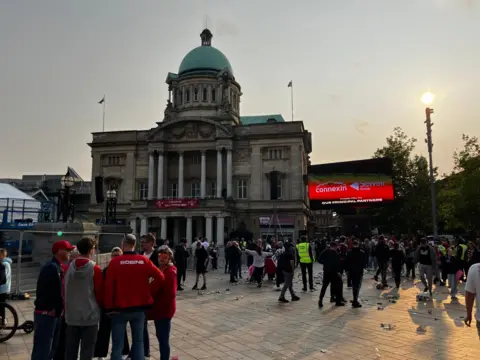 Crowds make their way from Queen Victoria Square in Hull. Litter has been left strewn across the ground.