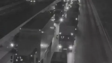 The lights of lorries show up in the dark with traffic at a standstill on the M6 southbound