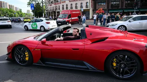 Getty Images Tristan Tate rijdt in een rode sportwagen in Boekarest, 2024