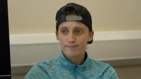 Megan, pictured in a turquoise tracksuit top and reversed black baseball cap