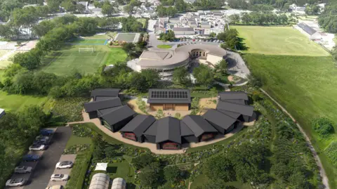 An aerial image of a school field with several black buildings in a semi-circle pattern