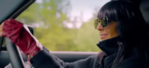 Claudia Winkleman driving a car on The Traitors