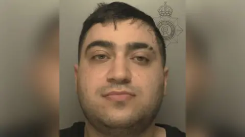 Custody photograph of Tony Cortez he has short black hair and is wearing a black shirt