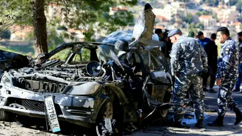 EPA Policemen inspect a destroyed vehicle