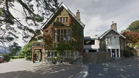 Google Large house with large windows on a sunny day.