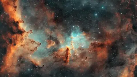 Lee Pullen/UrbanAstrophotography.com An image of deep space in orangey, black and turquoise colours. The stars are pinpricks set against a backdrop of cloud-like shapes and swirls 