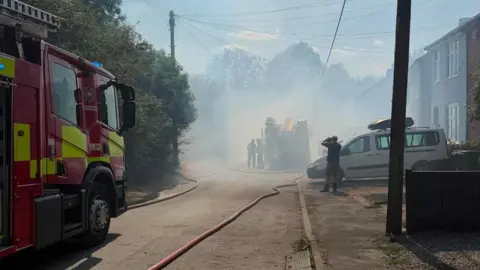Leicestershire Fire and Rescue Service Fire engines on a road with smoke in the air
