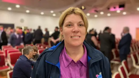 a woman in purple and blue in a conference room