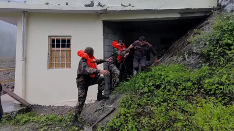 Reuters two devotions helps men, out of buildings affected by flash flood at Uttarakhand