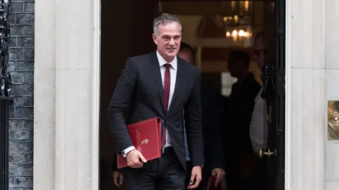 Getty Images Peter Kyle, a middle aged man, is wearing a suit as he walks out of the doors of Number 10 Downing Street.