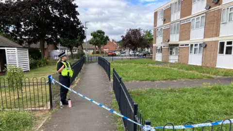 Police officer outside block of flats