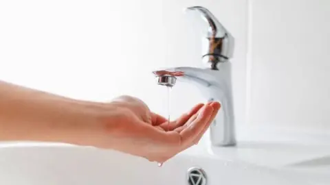 Getty Images Water running from a tap onto a hand