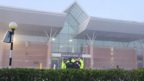 Jersey airport on the day of the incident in March. Police are stood outside the airport. 