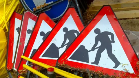 Image of five roadworks signs in a pile