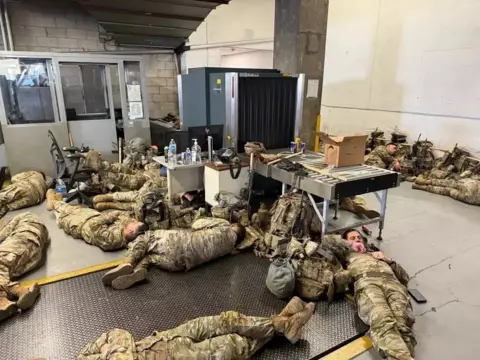 National Guard soldiers lie on the floor of an LA building following unrest
