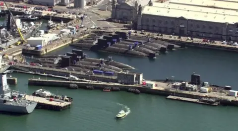 Aerial shot of Devonport dockyard in Plymouth. A number of submarines can be seen in the water.