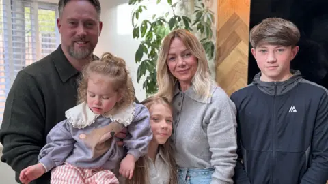 Family standing together in their home.