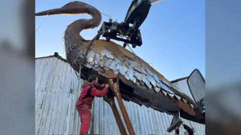 Stephanie Quayle and Darren Jackson A man working on a giant sculpture Heron