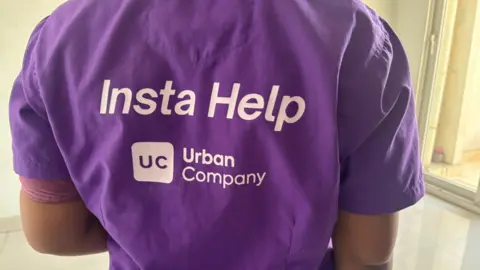 A woman wearing a bright purple shirt that says Insta Help at the back