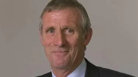 Senedd Cymru A tight head and shoulders image of Peter Rogers smiling taken in 1999, when he joined the Welsh Assembly