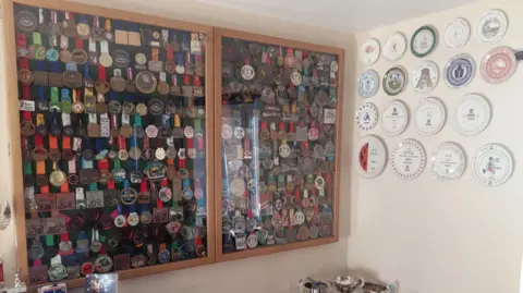 Steve Edwards Medal cabinets with hundreds of medals in