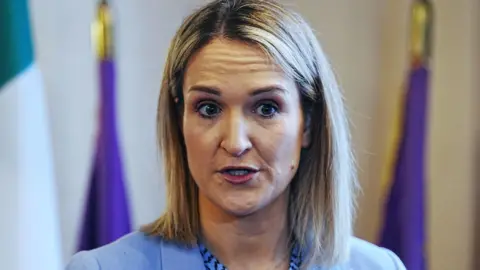 Helen McEntee, a woman with blonde hair, wearing a blue jacket.