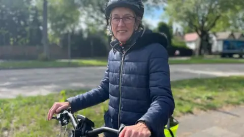 An image of Katherine, a resident of Wollaton. She is sat on her bicycle, wearing a helmet.