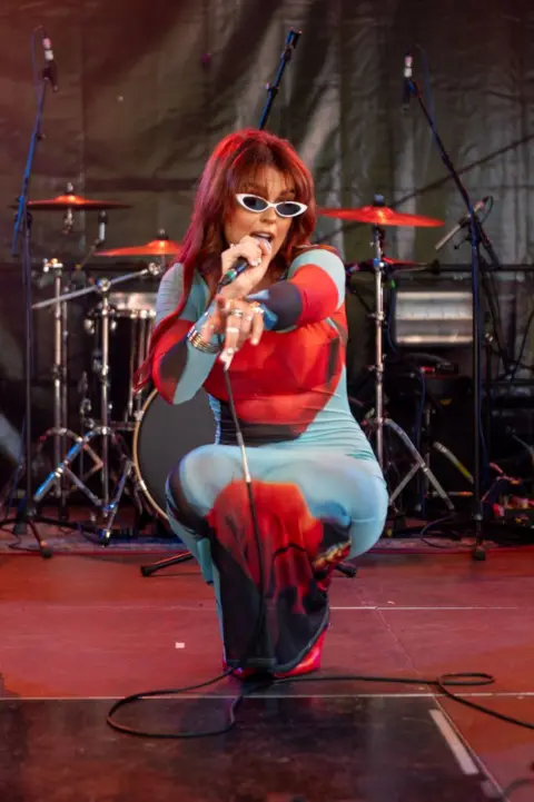 Getty Images Singer Tallia Storm kneeling down and pointing at camera