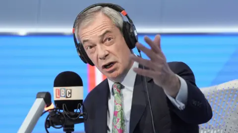 Nigel Farage gestures in an LBC radio studio