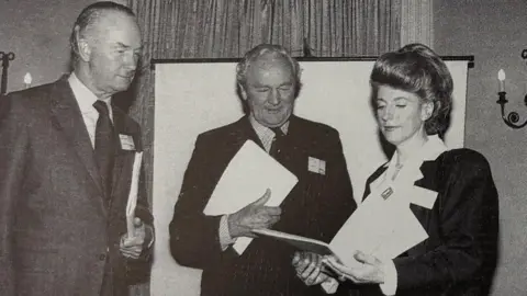 Wiltshire Community Foundation Two men and one woman staring into a brochure. The image was taken in 1993.